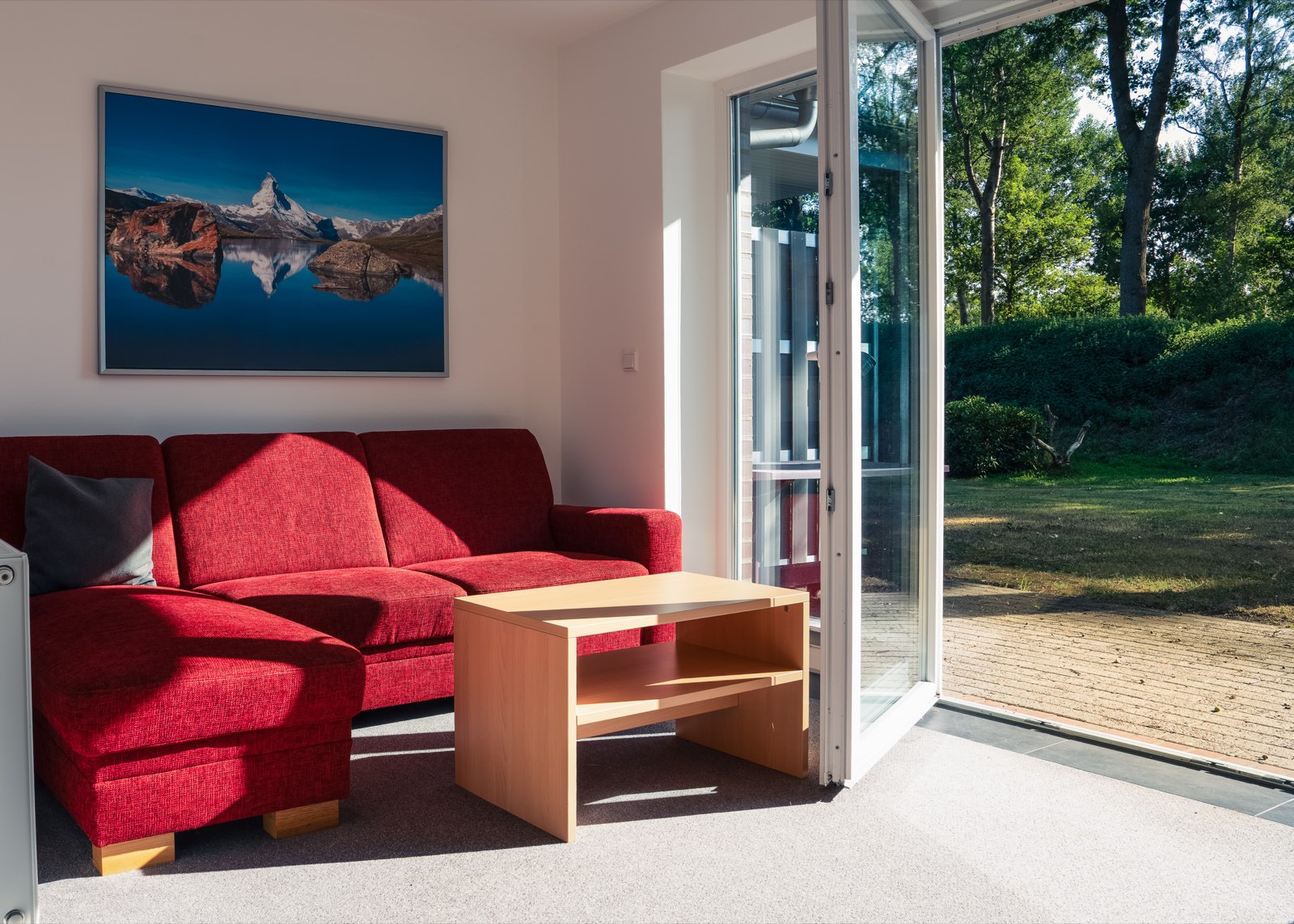 Sofaecke im Apartment des Hotel Ripken mit Blick durch die Terrassentür in den Garten