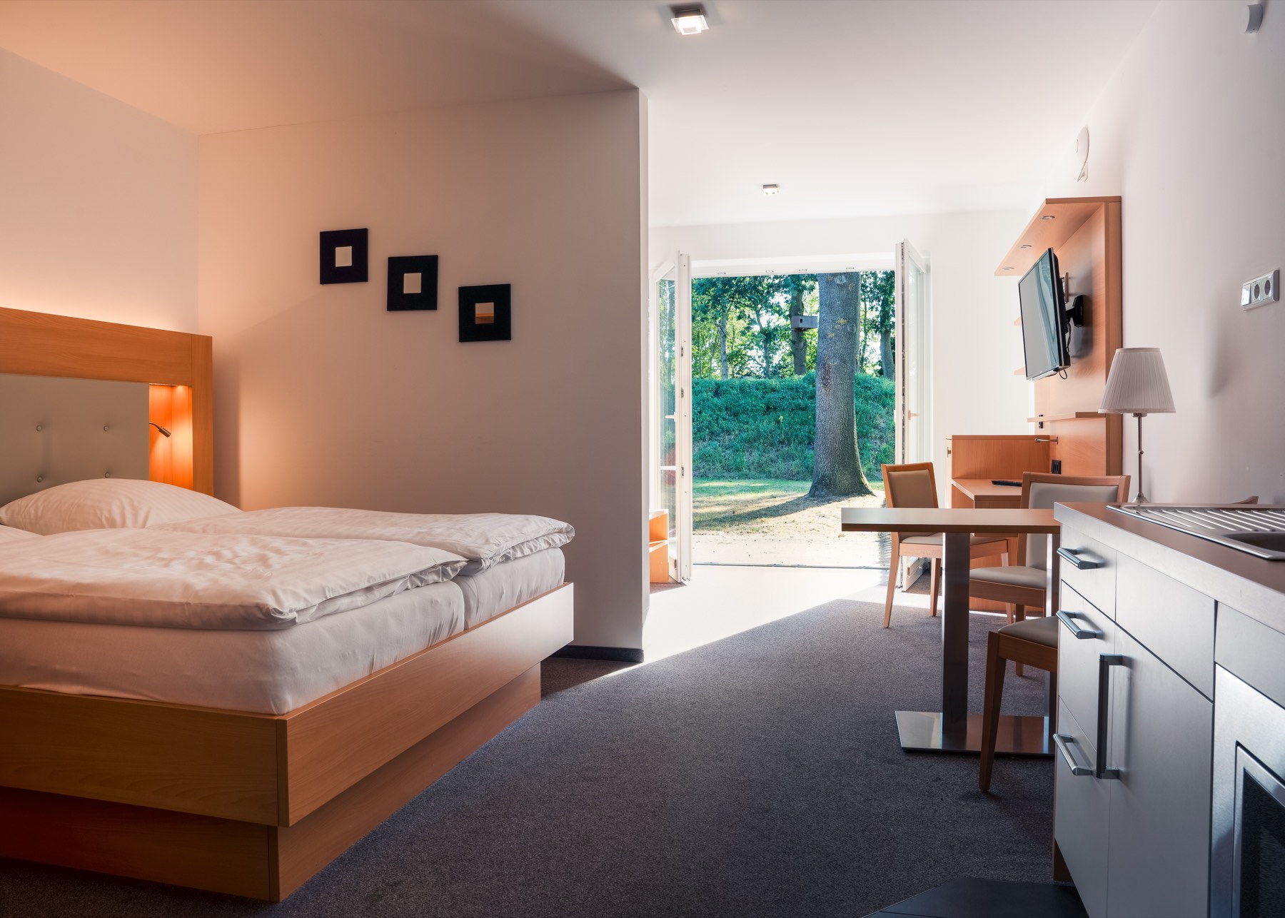 Wohn- und Schlafbereich eines Apartments im Hotel Ripken mit Flachbildschirm und offener Terrassentür