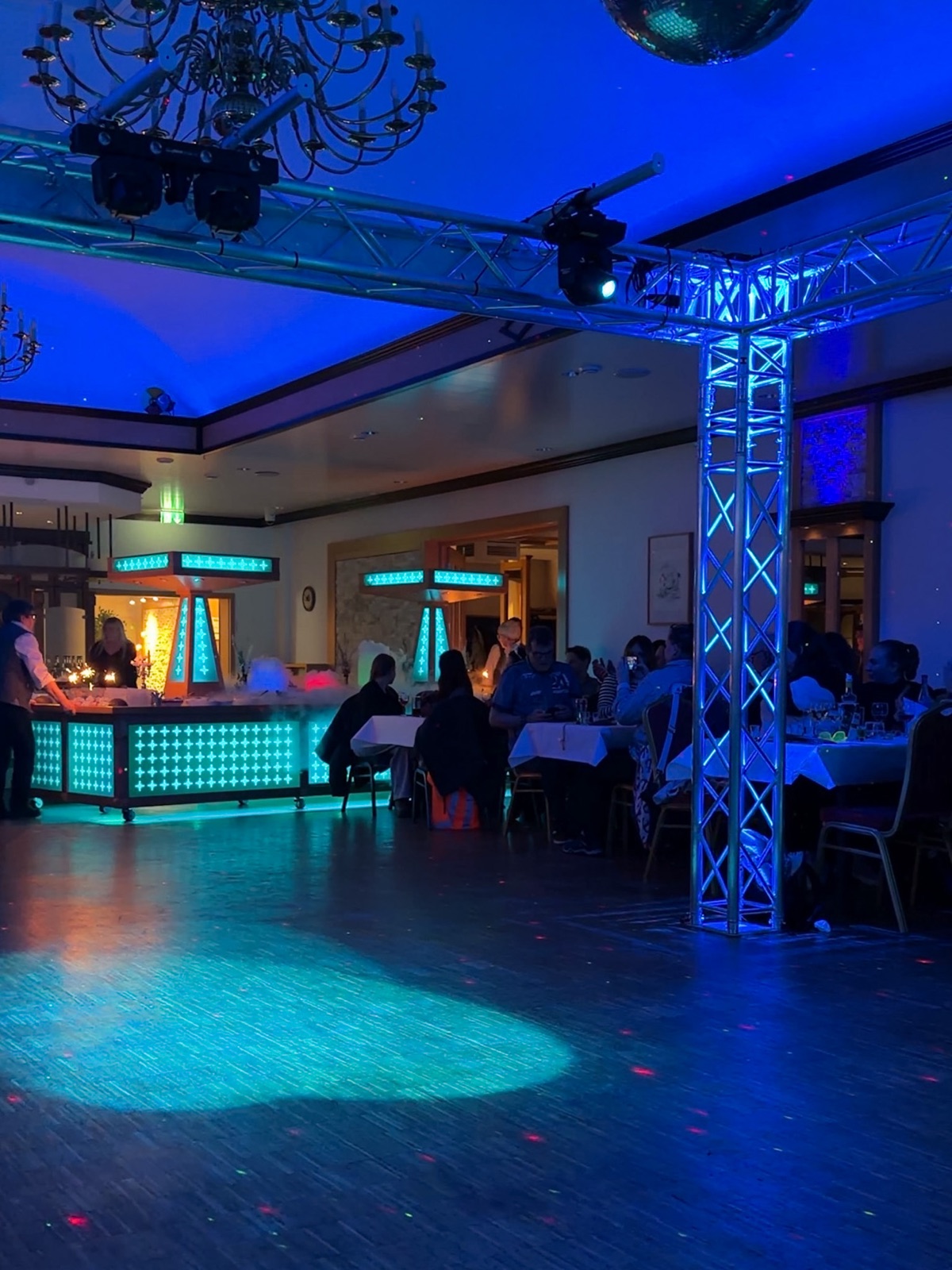 Festsaal im Hotel Ripken am Abend mit Tanzfläche, Lichtanlage und Gästen an gedeckten Tischen
