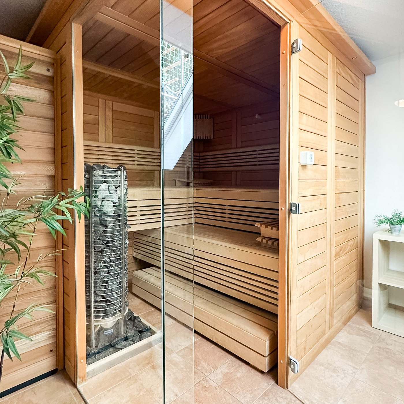 Sauna im Hotel Ripken mit Holzkabine, Saunaofen und Glastür