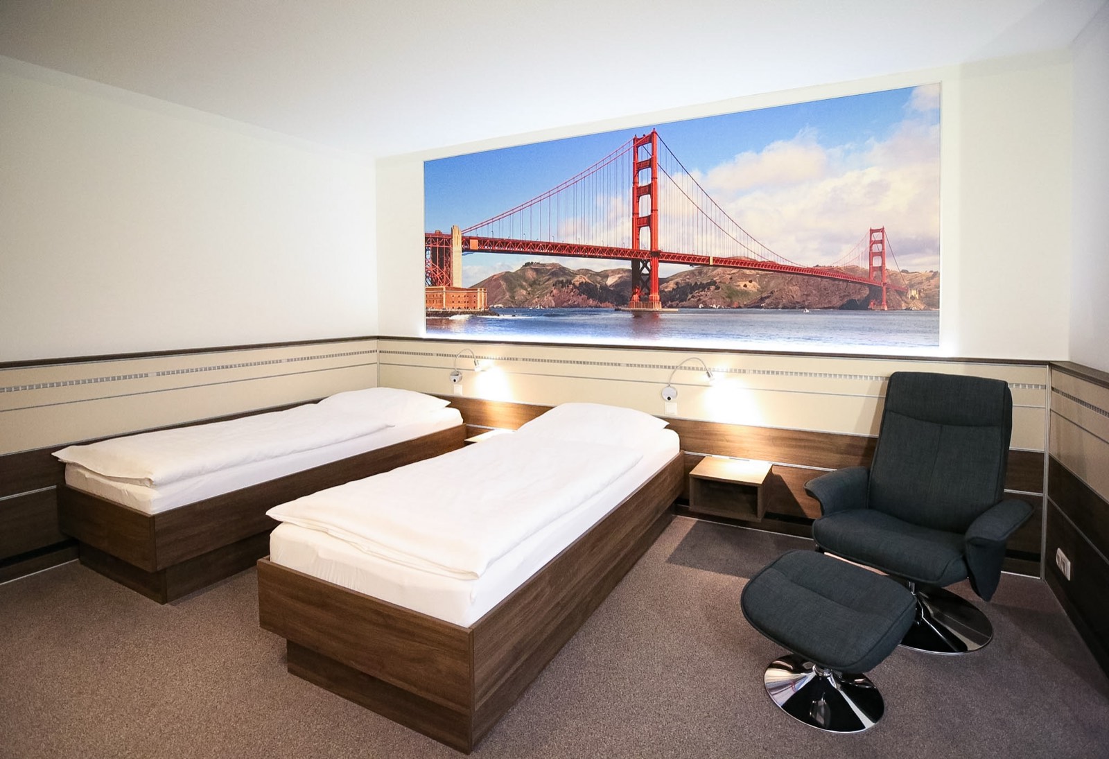 Themenzimmer San Francisco im Hotel Ripken mit Wandbild der Golden Gate Bridge und Relaxsessel